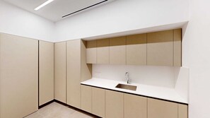 Une salle de bain moderne avec un lavabo intégré, des meubles de rangement et un luminaire.