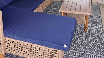 A covered porch with a wicker sofa and a small table.