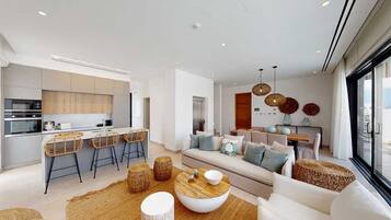 A modern living space with a kitchen, dining area, and seating area.