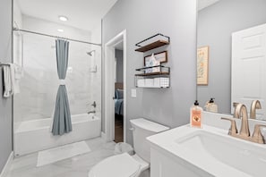 A modern bathroom with a glass shower enclosure, a bathtub, a toilet, and a vanity with a sink and mirror. - 7 Minutes to Campus! (Gainesville)