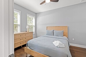 A bedroom with a bed, a nightstand, a dresser, and a window with blinds. - 7 Minutes to Campus! (Gainesville)