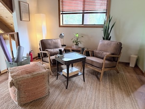 A living room with a sofa, armchairs, a coffee table, a rug, a potted plant, a lamp, and a framed picture on the wall. - Whispering Pines Sanctuary near Payette River & Hot Springs (Garden Valley)