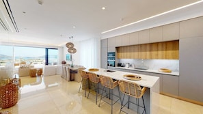 A modern kitchen with a large island, bar stools, and a view of the sea. - Secluded Seaside Bliss | Villa 1039 (Famagusta)
