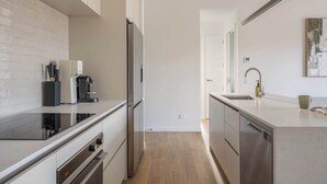 Eine moderne Küche mit Einbauofen, Kaffeemaschine und Geschirrspüler.
