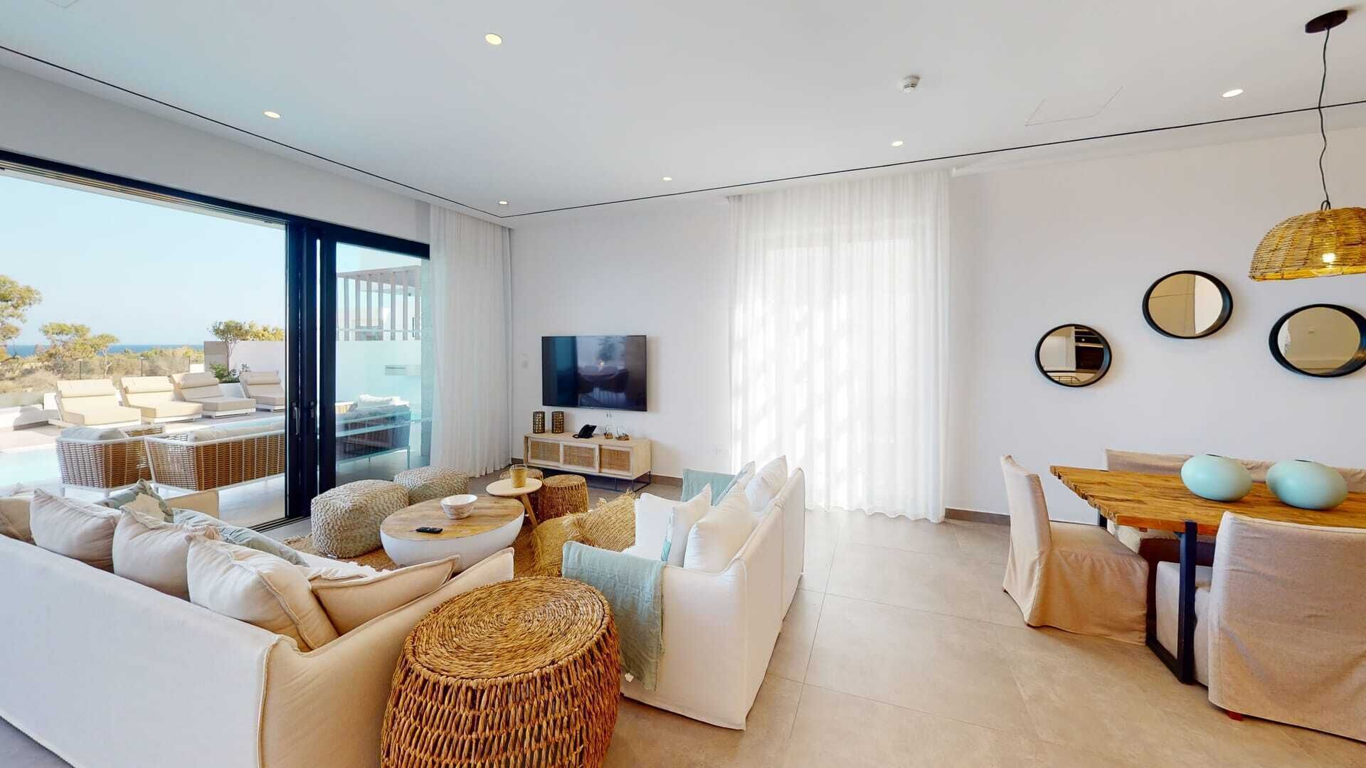 A modern living room with a sofa, a dining table, and a TV.