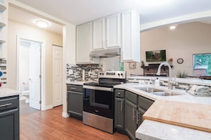 A modern kitchen with a built-in oven, a sink, and a wooden countertop. - Updated Mt Baker Retreat w/ Private Hot Tub + Pool (Deming)