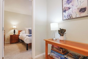 A bedroom with a bed, bedside table, lamp, and a wall-mounted painting. - Updated Mt Baker Retreat w/ Private Hot Tub + Pool (Deming)