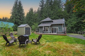 A two-story house with a deck, surrounded by a forest. - Updated Mt Baker Retreat w/ Private Hot Tub + Pool (Deming)