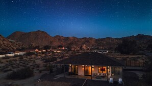 Una casa moderna con un patio y una vista despejada del cielo nocturno.