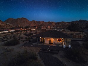Una casa moderna con un patio y una vista despejada del cielo nocturno.