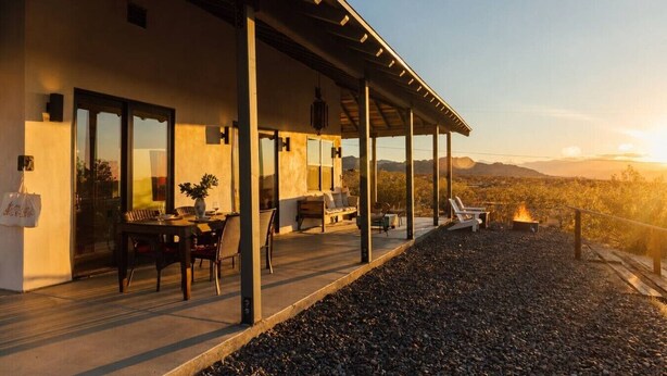 Un patio moderno al aire libre con comedor, asientos y una chimenea.