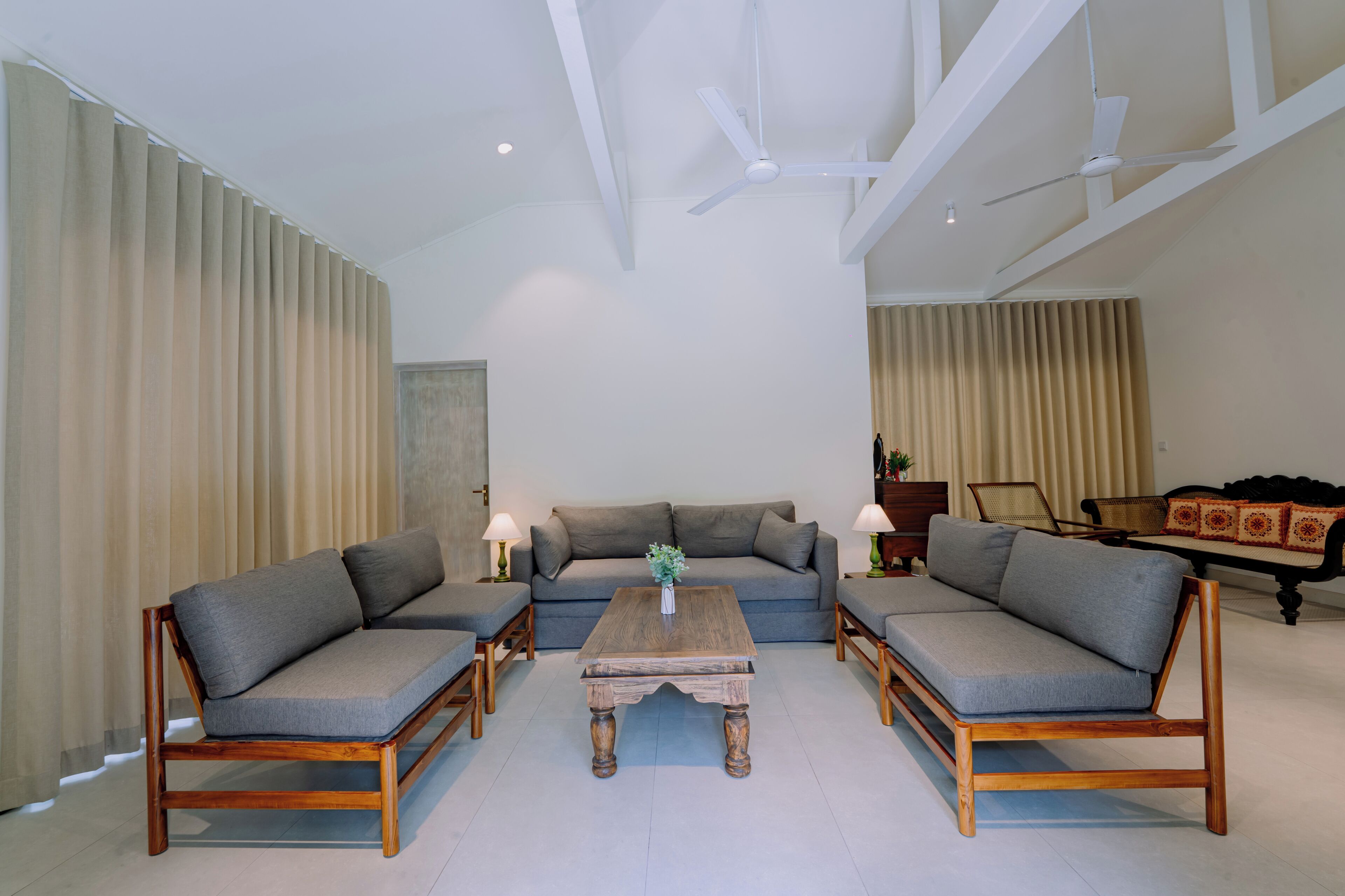 A modern living room with a sofa set, a coffee table, and a ceiling fan.