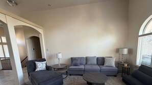 A living room with a grey sofa set, two side tables with lamps, a coffee table, and a carpeted floor. - Little Valley Oasis Resort Pool & Palm Paradise (St. George)