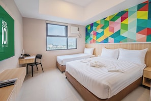 A hotel room with two beds, a desk, a chair, and a colorful geometric wall mural. - Hotel101 - Davao (Davao)