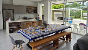 Una cocina moderna con zona de comedor, un banco y vistas al exterior.