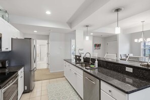 A modern kitchen with stainless steel appliances, a granite countertop, and pendant lighting. - Main Channel Views, 3 Heated Pools & Gated Resort (Lake Ozark)