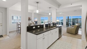 A spacious kitchen with a large island, white cabinetry, and a view of the outdoors. - Main Channel Views, 3 Heated Pools & Gated Resort (Lake Ozark)