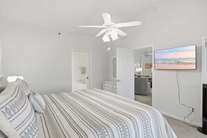 A bedroom with a bed, a ceiling fan, a TV, and a view of the kitchen. - Main Channel Views, 3 Heated Pools & Gated Resort (Lake Ozark)