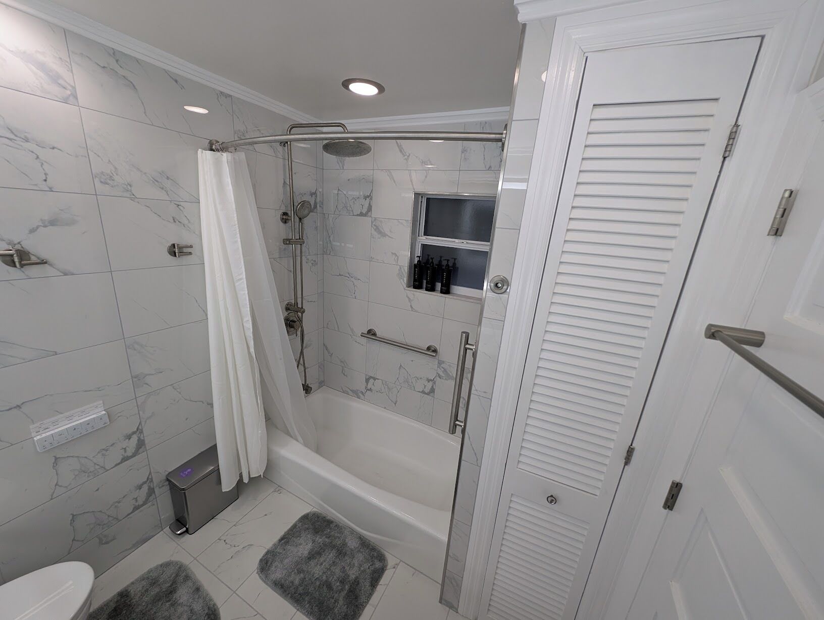 A modern bathroom with a shower, toilet, and a walk-in closet.