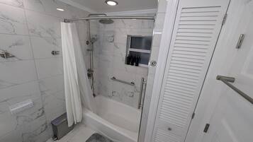 A modern bathroom with a shower, toilet, and a walk-in closet.