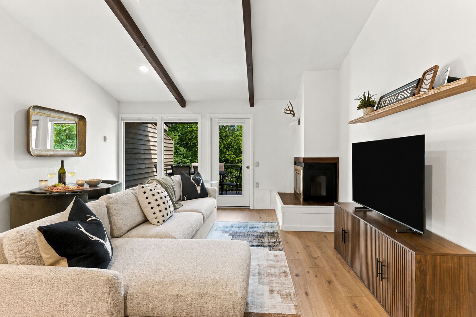 Una sala de estar moderna con sofá, televisor y chimenea.