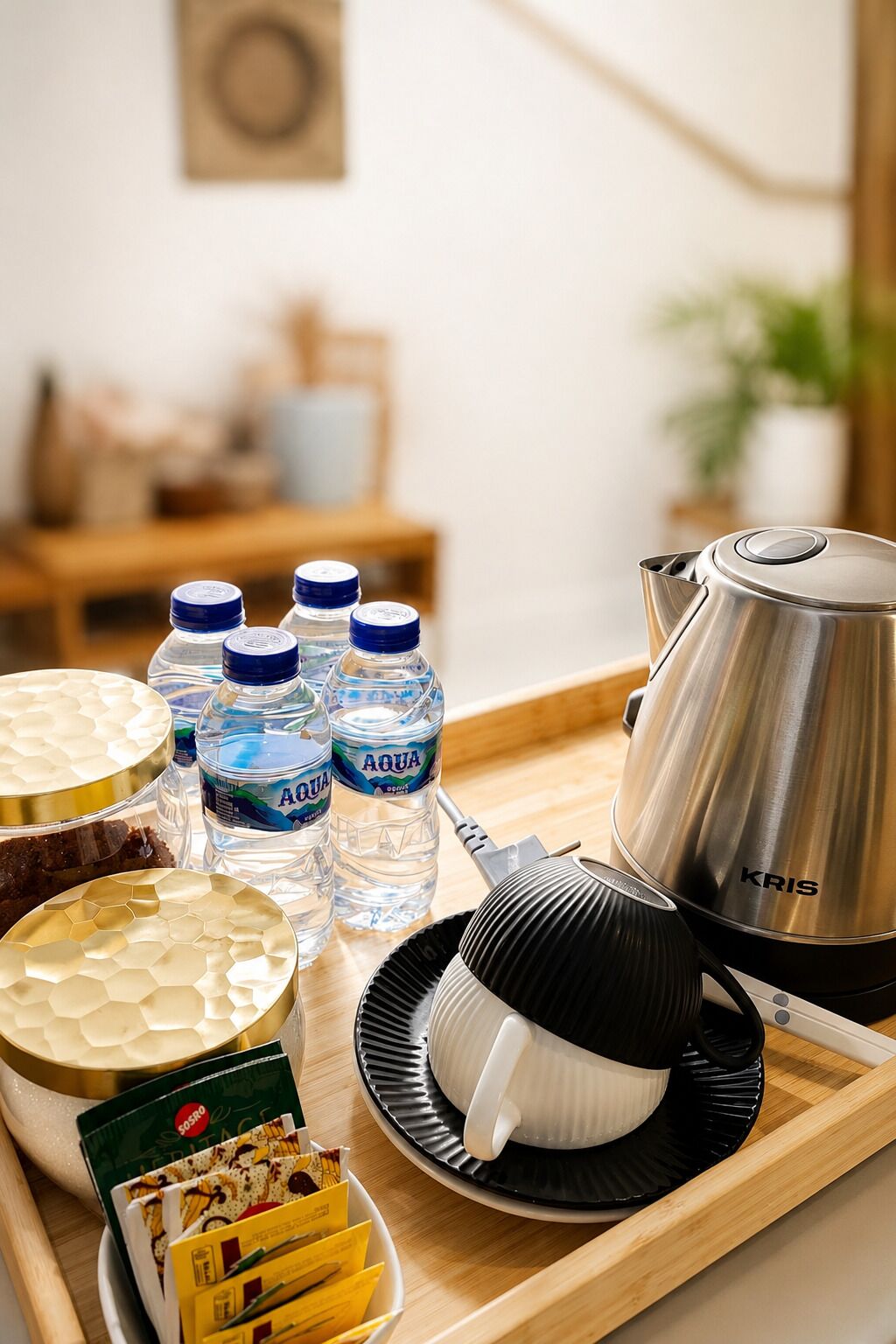A tray with a water bottle, a coffee pot, a honeycomb-patterned container, a black and white cup, and a plate with snacks.