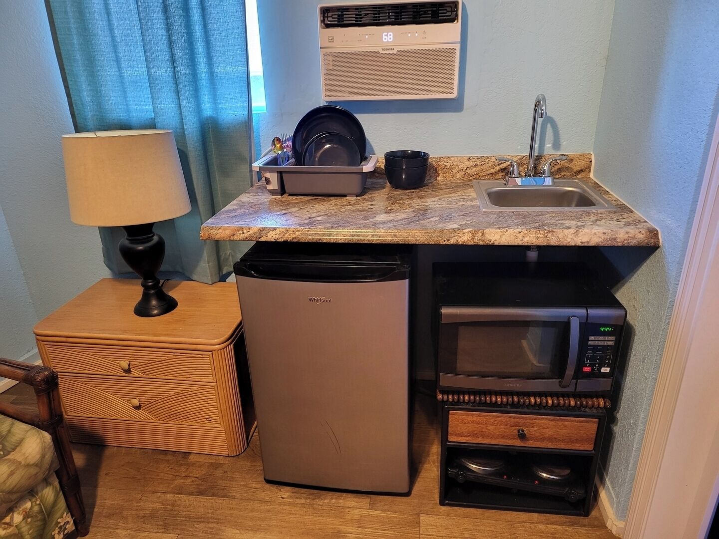 A compact kitchenette with a refrigerator, microwave, and sink.