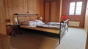 A single bed with a metal frame in a room with wooden walls and a sloped ceiling. - Via Cuort, Brigels, (Breil/Brigels), 65083B by Interhome (Breil/Brigels)
