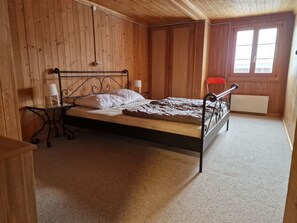 A single bed with a metal frame, a bedside table with a lamp, and a window with a view of the outside. - Via Cuort, Brigels, (Breil/Brigels), 65083B by Interhome (Breil/Brigels)