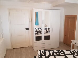 A bedroom with a bed, a wardrobe, and a wooden door. - Casa Spescha, Tavanasa, (Tavanasa), 65059B by Interhome (Tavanasa)