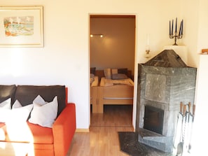 Ein gemütliches Wohnzimmer mit einem roten Sofa, einem Kamin und einem Bild an der Wand.