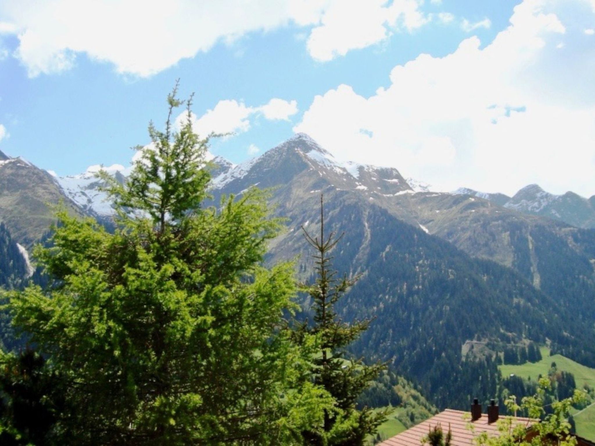 A mountain landscape with snow-capped peaks and a clear sky.