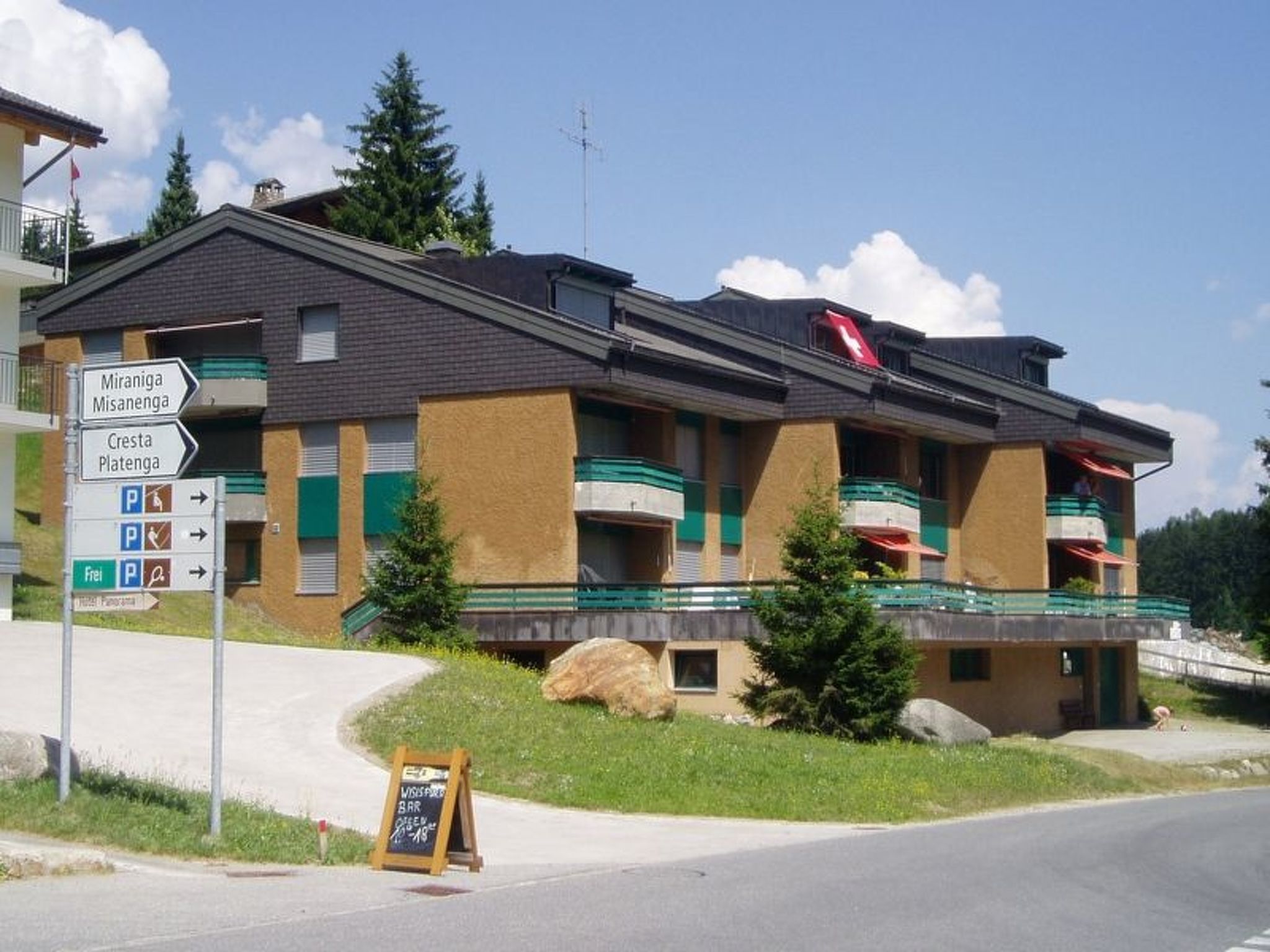A hotel with a sign indicating directions to Miraniga, Misanenga, Cresta, and Platenga.