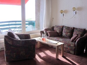 A living room with a sofa, armchair, and a coffee table. - Nodahüs Steiger, Obersaxen-Affeier, (Obersaxen), 34004B by Interhome (Obersaxen Affeier)