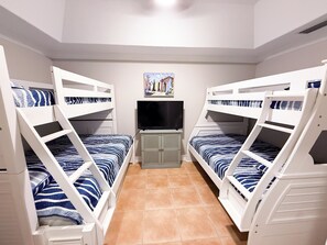 A room with bunk beds, a television, and a cabinet. - Walk to the beach. Two pools, hot tub, tennis. (St. Augustine)