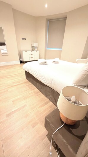 A modern bedroom with a large bed, bedside table, and a lamp. - Private Elevator Marylebone Apartment Central Lond (London)