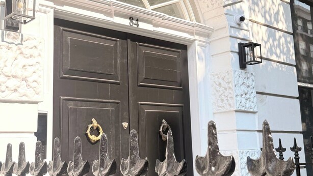 A building facade with a black double door, a white arched window, and a decorative metal fence. - Private Elevator Marylebone Apartment Central Lond (London)
