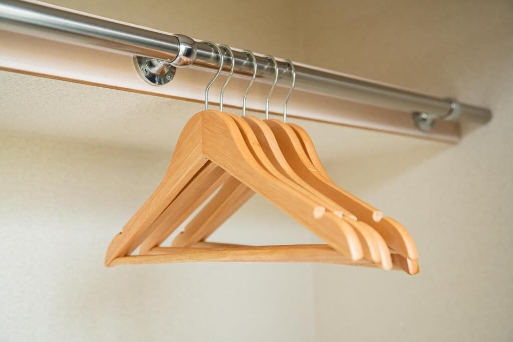 A wooden hanger on a metal rod.