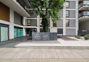 A modern apartment building with a sign for 'Union Apartment' and a tree in the center. - Wola Jaktorowska Urban Studio (Warszawa)