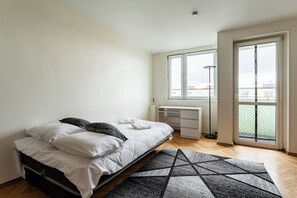 A bedroom with a bed, a desk, and a window. - Baltic Seaside Homely Apartment (Gdańsk)