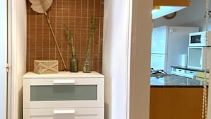 A room with a white cabinet, a feather, and two green bottles on a shelf. - Apartment with a sea views in Levantina, Sitges (Sitges)