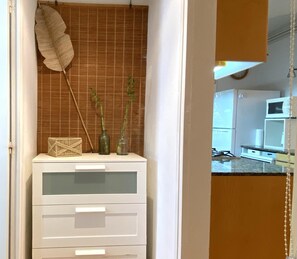 A room with a white cabinet, a feather, and two green bottles on a shelf. - Apartment with a sea views in Levantina, Sitges (Sitges)