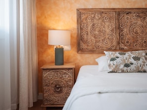 A bedroom with a bed, a nightstand with a lamp, and a decorative headboard. - Penthouse, 200m from the beach w/ parking (Cubelles)