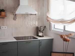 A kitchen with a white range hood, a coffee machine, and a window with a view. - Penthouse, 200m from the beach w/ parking (Cubelles)