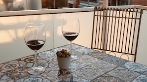 A table with two wine glasses and a small bowl of olives on a patterned tile table. - Penthouse, 200m from the beach w/ parking (Cubelles)
