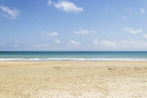 Ein Strand mit blauem Himmel und ruhigem Meer.