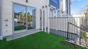 A modern house with a white exterior, a blue accent wall, and a well-maintained lawn.