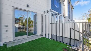 A modern house with a white exterior, a blue accent wall, and a well-maintained lawn.