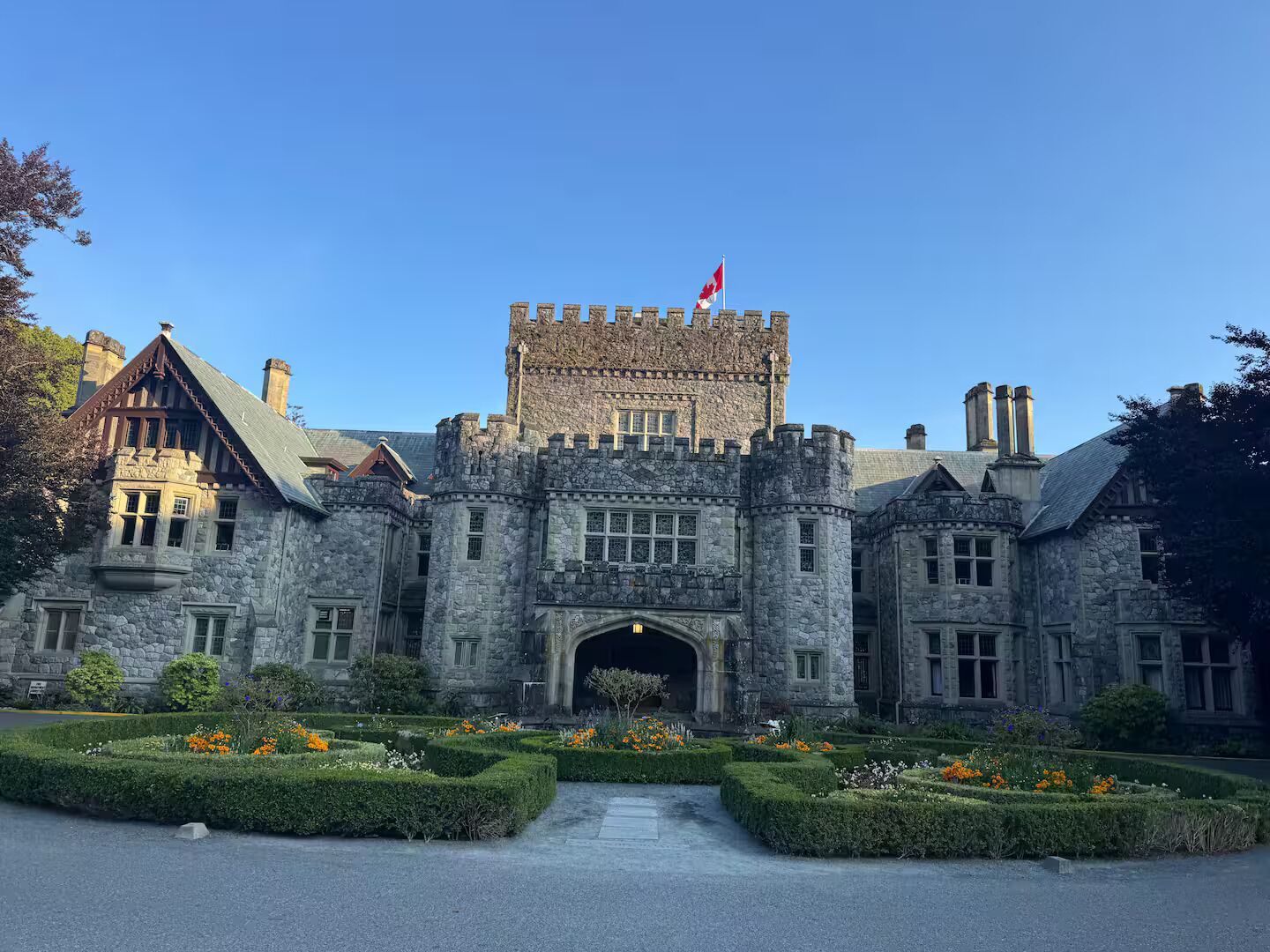 A large stone castle-like building with a central entrance and a flag on top.