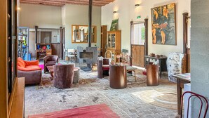 Un intérieur spacieux agrémenté d’une cheminée, d’un coin salon et d’œuvres d’art aux murs.